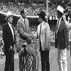 Chas Weldon presenting the saddle he made for Nolan Ryan as Bill Reynolds and Gene Autry look on.